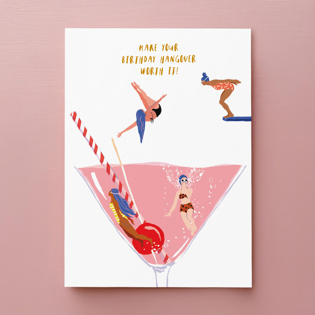 Illustration of people in swimwear diving and swimming in a large pink cocktail glass with a cherry and straw. Text above reads, Make your birthday hangover worth it!.